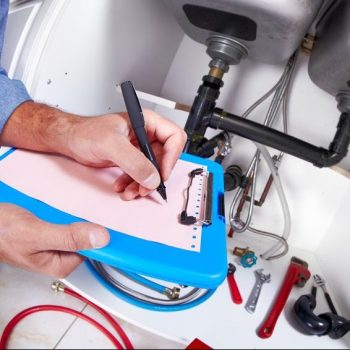 Plumber hands writing on clipboard. Plumbing and renovation .